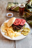 Grilled Buffalo Burger with Lettuce and Tomato Served with Potato Chips, Pickles and Beer