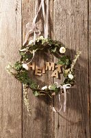 Wreath made of ivy and daisies and the word 'home'