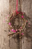 Wreath made from dried branches with pink forget me nots and carnations