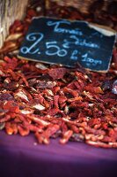 Dried tomatoes on a market stall with a price label