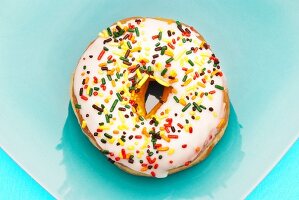 Doughnut mit Zuckerglasur und bunten Zuckerstreuseln