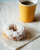 Coconut Doughnut on a Napkin with Coffee in a Paper Cup