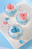 Cupcakes decorated with marzipan flowers and sugar balls