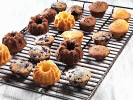 Assorted muffins and small Bundt cakes on a cooling rack