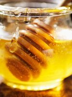 Honig im Glas mit Honiglöffel (Close Up)