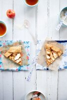 Apple Tart Slices on Paper; Plastic Spoons