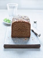 Mixed rye and wheat bread, partly sliced, on a wooden board