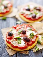 Mini pizzas with beef tomatoes, olives and pesto