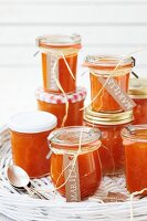 Several jars of apricot jam on a wicker tray