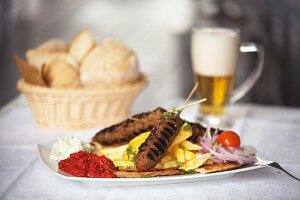 Gegrillte Hackfleischspieße mit Pommes frites und Dips