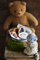 Mini pancakes with berries and yoghurt sauce in a bowl surrounded by stuffed animals