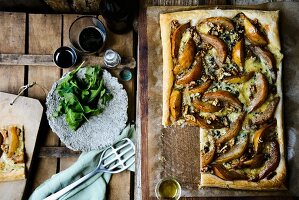 Puff pastry tart with pears, blue cheese, walnuts and rocket, one slice served