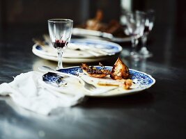 The remains of roast chicken with lemons, onions and thyme, on plates