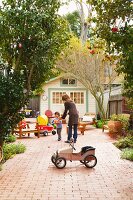 Mother and child surrounded by seating and toys in courtyard