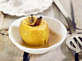 A baked apple with a cinnamon stick