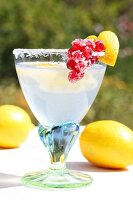 'Cold Duck' punch in a glass with a sugared rim, decorated with a heart made from lemon peel and with candied redcurrants