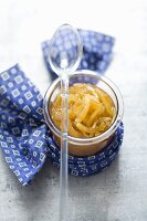 A jar of lemon curd with a spoon