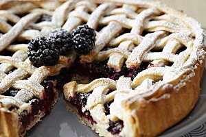 A sliced blackberry tart with a lattice pastry top