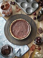 Chocolate tart surrounded by ingredients (seen from above)