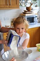 Kleines Mädchen hilft der Mutter beim Backen