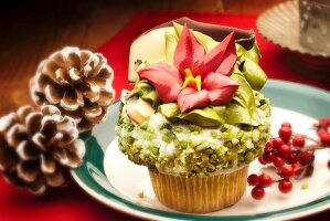 Vanilla cupcake decorated with pistachios and a flower for Christmas