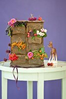 Small chest of drawers decorated with autumnal berries & flowers