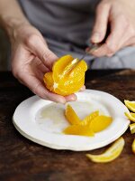 An orange being filleted with a small knife