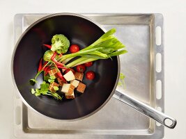 Tofu and raw vegetables in a wok