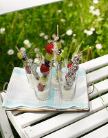 Obstspieße mit Kokosraspeln in Gläsern