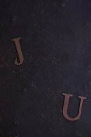Paper J and U letter on a dark background