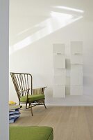 Modern shelving with white screen elements behind fifties-style armchair