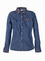 A denim blouse with colourful embroidery on the collar and the breast pocket