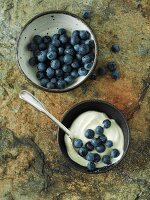A bowl of fresh blueberries and a bowl of blueberries in cream
