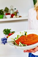 Frau trägt Schüssel Detox Zucchinipasta mit Tomatensauce