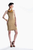 A young woman wearing a gold coloured Lurex knitted dress with yellow jewellery