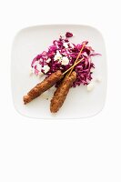 Red cabbage salad with cinnamon, feta cheese and minced meat skewers