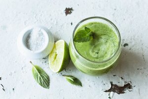 Green spinach smoothie with herbs, cucumber, avocado and celery