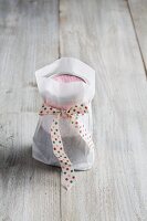 A preserving jar in a paper bag tied with a ribbon
