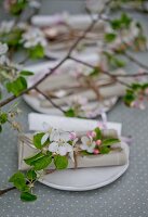 Apfelblüten mit Besteck und Papierrollen mit Namen