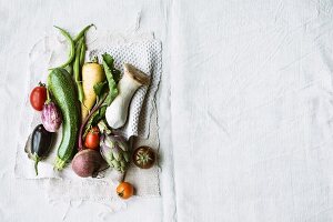 Various types of vegetables and king trumpet mushrooms on a linen cloth