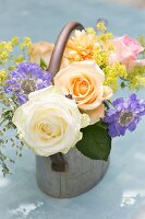 Romantic posy of roses and scabious in metal watering can
