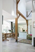 Open-plan interior with exposed wooden structure, gallery and dining area