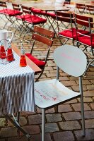 A chair decorated with quotes at an outside restaurant table