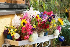 Colourful beakers of summer garden flowers