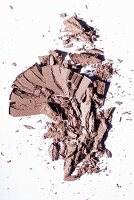 Brown eye shadow crumbled on a white surface