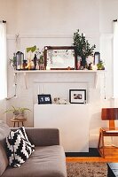 Cushion with graphic pattern on grey sofa in front of wall-mounted shelf