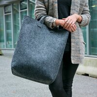 A woman with a large bag made from grey felt