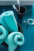 Rolled, turquoise towel in a container