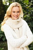 Junge Frau in weisser Strickjacke und Schal in Grobstrick