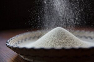 Cornflour being sprinkled into a basket bowl